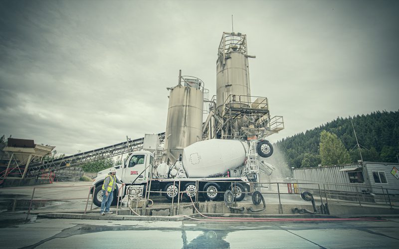 Concrete mixer trucks beneath batch plant silos