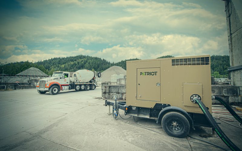 Patriot tan pump unit on site with concrete mixer trucks