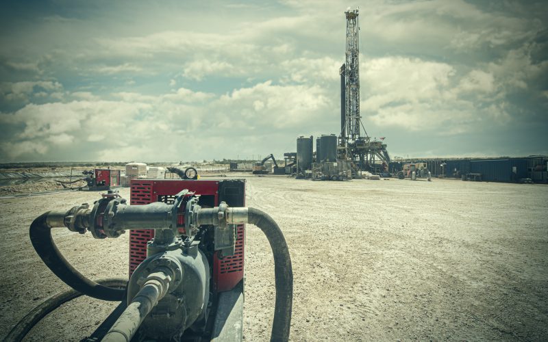 Pump discharge hose running toward the drill rig
