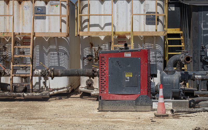 Patriot pump unit installed beside wellsite storage tanks