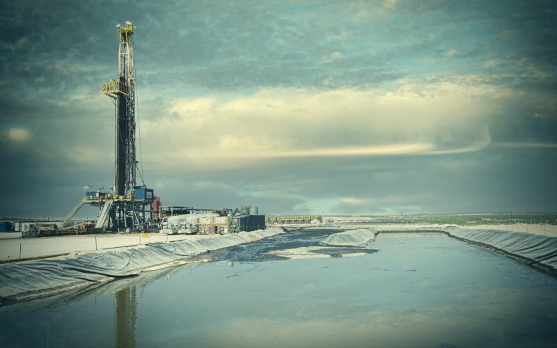 Panorama of a drilling rig and lined reserve pit in West Texas