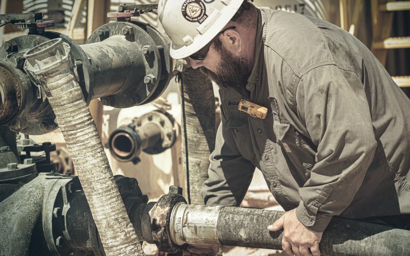 Crew member handling drill pipe on the rig floor