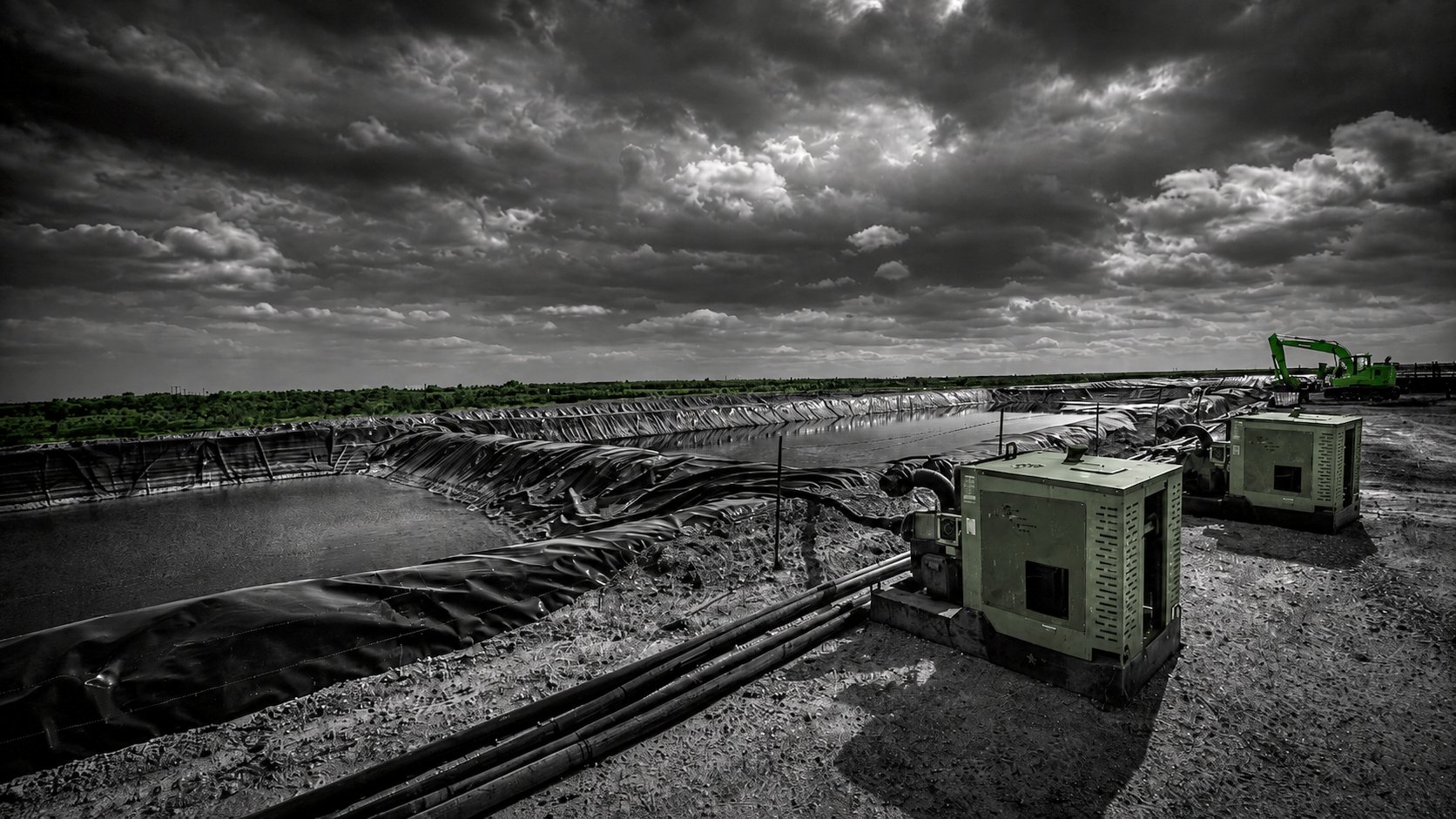 Two Patriot pump units dewatering a lined retention pond at a Midland site with an excavator in the background